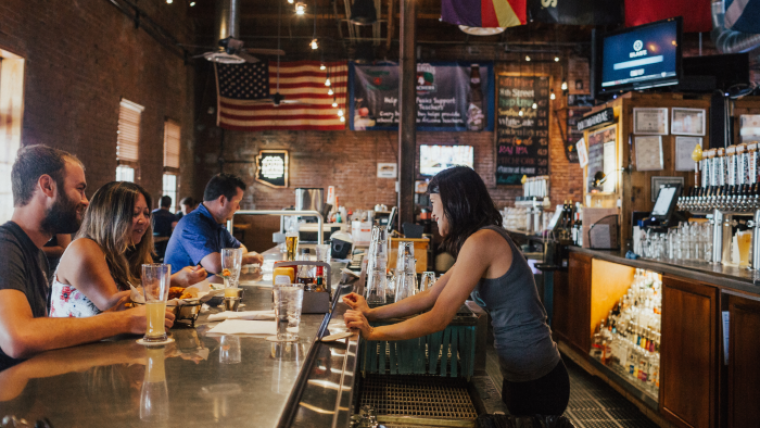 Background music in colourful bar scenario with female bar tender and happy customers present