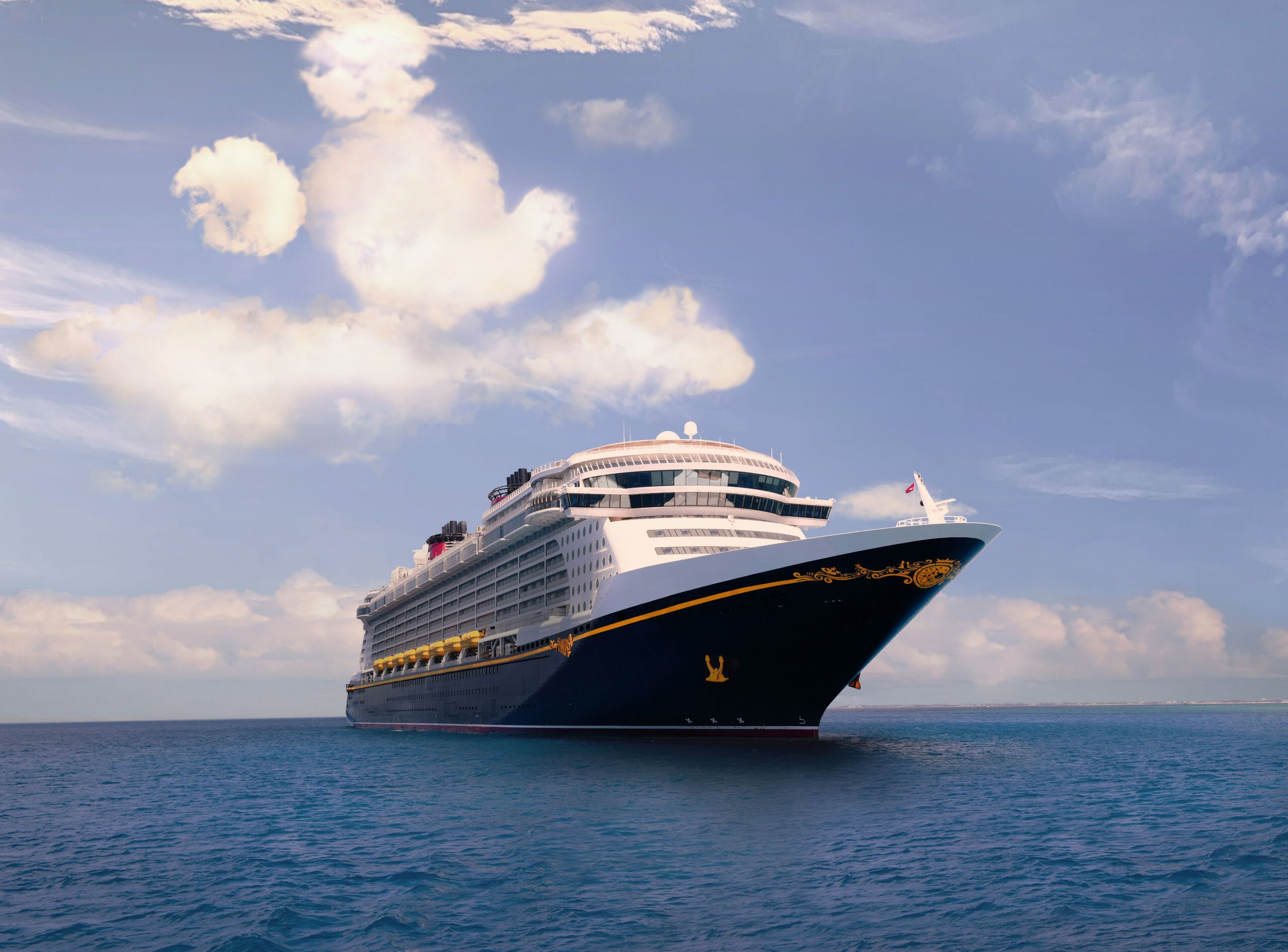 Disney Cruise Liner at sea with clouds in the shape of Mickey Mouse's head